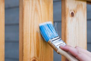 paint brush painting an outdoor fence