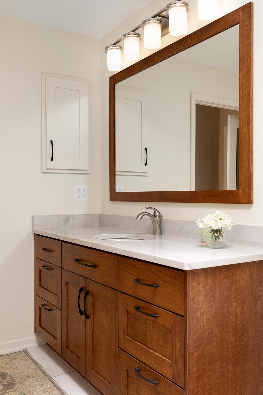 Custom oak cabinet and mirror frame in accessible design bathroom